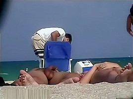 A nude beach voyeur films a...