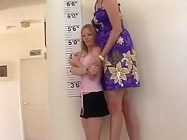 Tall woman compares heights with shorter...