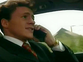 Men converse on phones in car...